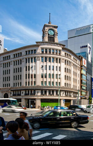 Die Fahrgeschwindigkeiten über die Ginza Yonchome Kreuzung in Tokio, Japan, Aufstellungsort der Wako Kaufhaus mit seinem Wahrzeichen Clock Tower Stockfoto