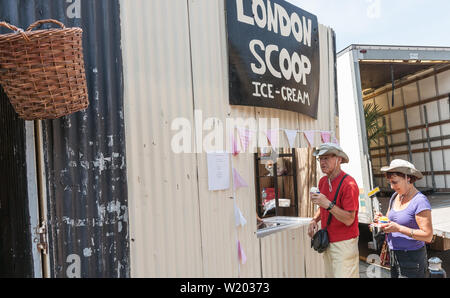 LONDON ENGLAND - 14 Juli 2013; Paar für Hüte Eis kaufen - Creme aus dem Fenster openng in Wellblech Wand mit unterzeichnen oben für London Schaufel. Stockfoto