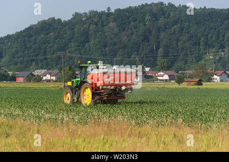 John Deere Traktor mit roten Tank in der Rückseite spritzen auf ein Feld Stockfoto