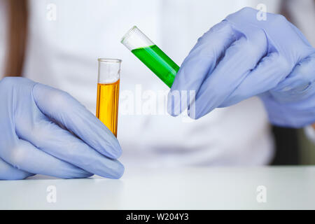 Biologische Tests. Frau mit Kolben in Lab. Der Wissenschaftler, Dermatologe testen die organische Naturprodukt im Labor Stockfoto