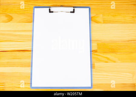 Büro Hand mit einem Ordner mit einer weißen Farbe Papier auf dem Hintergrund der hölzernen Tisch. Copyspace. Platz für Text Stockfoto
