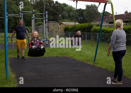 Eltern spielen mit ihren Kindern in einem Park, Großbritannien Stockfoto