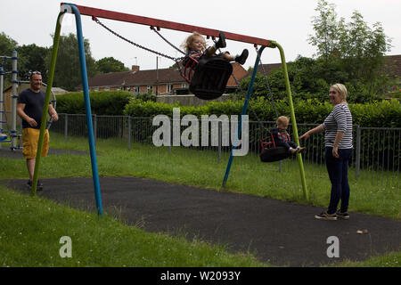 Eltern spielen mit ihren Kindern in einem Park, Großbritannien Stockfoto