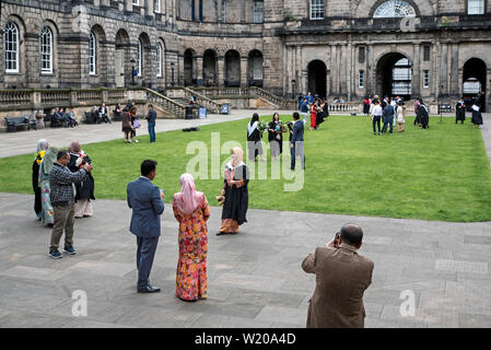 Asiatische Studenten von der Universität von Edinburgh Abschluss posieren für Fotos mit Familie und Freunden in der Quad der Alten Hochschule auf South Bridge. Stockfoto