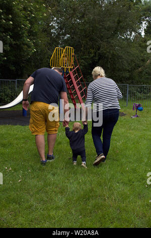 Kleinkinder lernen im Park mit Eltern zu Fuß Stockfoto