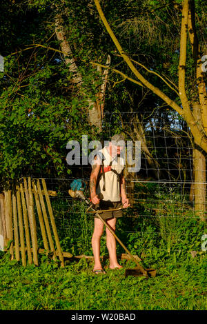 Mann mit einem STRIMMER, Gras und Unkraut im Garten zu schneiden Ungarn Zala county Stockfoto