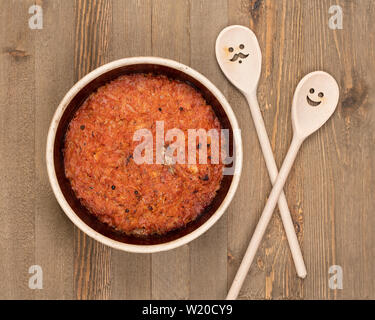 Eine Keramik Topf der traditionellen Osteuropäischen gedünstetem Rosenkohl und dekoriert Holzlöffel auf braunem Holz- Küche. Stockfoto