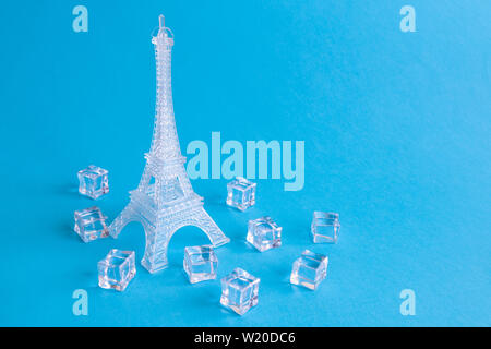 Eiffelturm aus Eis und Eiswürfel vor blauem Hintergrund minimal kreatives Konzept. Platz für Kopieren. Stockfoto