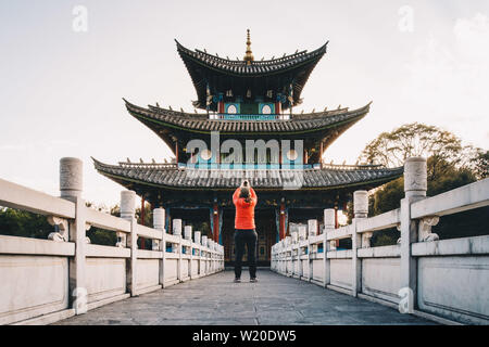 Eine Person ist unter Foto von Wufeng Pavillon, Yugan Park in Lijiang Altstadt, in China, in der Provinz Yunnan mit Stockfoto