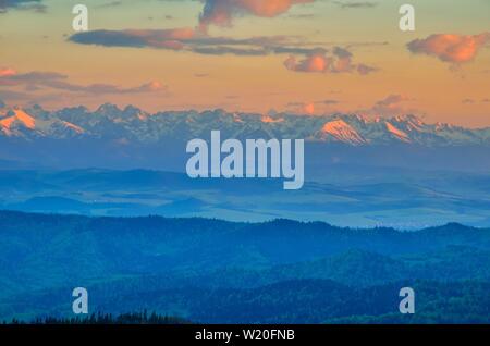 Schöne Berglandschaft. Schneebedeckte Berge im Licht der untergehenden Sonne. Stockfoto