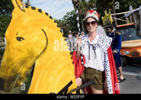 Eine Frau in Tracht reitet ein Fahrrad als Pferde während der jährlichen Tag der Unabhängigkeit Golfkarre und Fahrrad parade Juli 4, 2019 in Sullivan's Island, South Carolina eingerichtet gekleidet. Die winzigen wohlhabenden Sea Island Strand Gemeinschaft gegenüber von Charleston hält eine überdimensionale Golfkarre Parade mit mehr als 75 eingerichtete Karren. Stockfoto