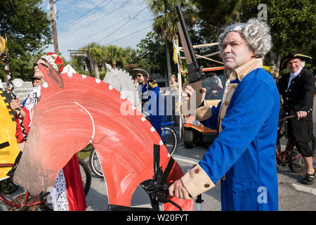 Ein Mann in der Kolonialen Kostüm reitet ein Fahrrad als Pferde während der jährlichen Tag der Unabhängigkeit Golfkarre und Fahrrad parade Juli 4, 2019 in Sullivan's Island, South Carolina eingerichtet gekleidet. Die winzigen wohlhabenden Sea Island Strand Gemeinschaft gegenüber von Charleston hält eine überdimensionale Golfkarre Parade mit mehr als 75 eingerichtete Karren. Stockfoto