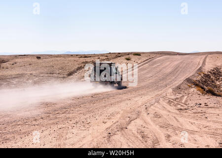 Toyota Hilux Antriebe entlang einer Schotter Piste verlassen eines Staub Trail in Zentral Namibia Stockfoto