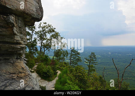 Regen kann in der Entfernung von der Jomeokee Trail, die Kreise der ikonischen Pinnacle am Pilot Mountain State Park in North Carolina gesehen werden. Stockfoto