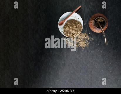 Künstlerische Fotografie der yerba mate Infusion, typische aus Argentinien, in eine weiße Platte, über einen dunklen Hintergrund Stockfoto