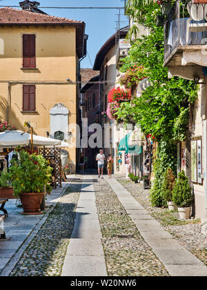 Touristen schlendern Sie durch die Straßen des Dorfes Orta San Giulio am Ortasee Italya während einem Sommernachmittag Stockfoto