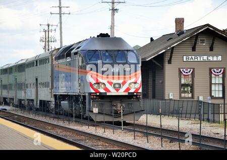 Bartlett, Illinois, USA. Ein Metra Lokomotive drücken ein Nahverkehrszug, wie es die Bartlett Station auf seiner Reise nach Chicago verlässt. Stockfoto
