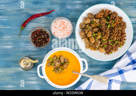 Gerichte mit Pilzen in Platten auf Tisch Stockfoto