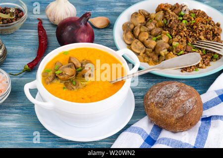 Gerichte mit Pilzen in Platten auf Tisch Stockfoto