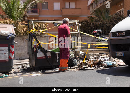 Roma, Italien. 03 Juli, 2019. Einige AMA Betreiber gehen Sie mit der Sammlung von Abfällen in eine Straße im Stadtteil von Rom Monteverde nach dem Brennen von einem Müllcontainer Credit: Matteo Nardone/Pacific Press/Alamy leben Nachrichten Stockfoto