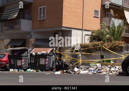 Roma, Italien. 03 Juli, 2019. Einige AMA Betreiber gehen Sie mit der Sammlung von Abfällen in eine Straße im Stadtteil von Rom Monteverde nach dem Brennen von einem Müllcontainer Credit: Matteo Nardone/Pacific Press/Alamy leben Nachrichten Stockfoto