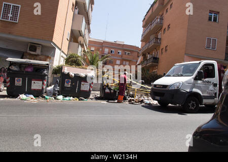 Roma, Italien. 03 Juli, 2019. Einige AMA Betreiber gehen Sie mit der Sammlung von Abfällen in eine Straße im Stadtteil von Rom Monteverde nach dem Brennen von einem Müllcontainer Credit: Matteo Nardone/Pacific Press/Alamy leben Nachrichten Stockfoto