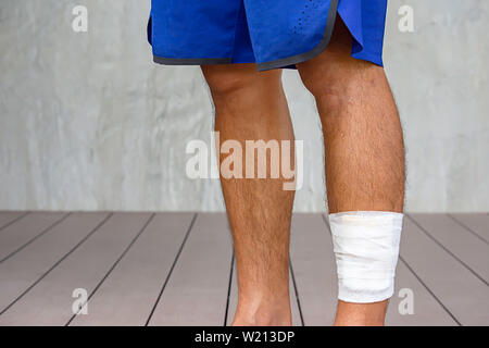 Die weiße Gaze Bandagen um die Beine Hintergrund Wand- und Holzboden. Stockfoto