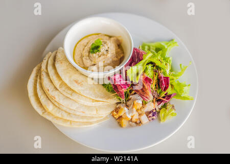 Hummus mit tortillas auf einem weißen Tisch Stockfoto