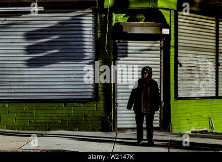 Eine Frau steht an einer Straßenecke im Winter in West Philadelpia Stockfoto