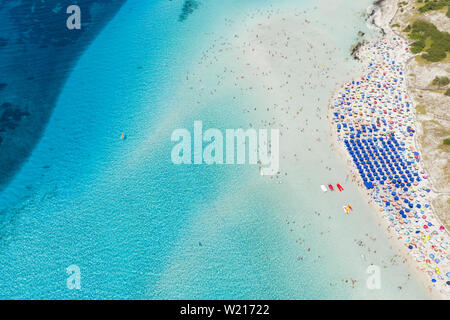 Beeindruckende Luftaufnahme der Spiaggia della Pelosa (Pelosa Strand) voll von bunten Sonnenschirmen und Menschen sonnenbaden. Stockfoto