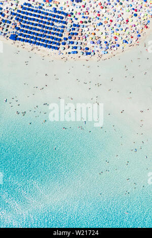 Beeindruckende Luftaufnahme der Spiaggia della Pelosa (Pelosa Strand) voll von bunten Sonnenschirmen und Menschen sonnenbaden. Stockfoto