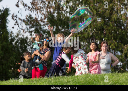 Kinder spielen mit riesigen seifenblasen am Seafair Sommer vierten Independence Day Feier am Gas Park am 4. Juli, 2019 in Seattle, Washington. Stockfoto