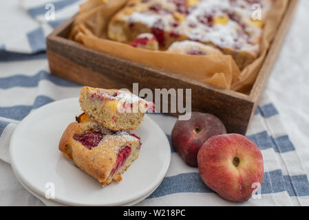 Hausgemachte Mandel Kuchen mit Pfirsich und Himbeeren Stockfoto