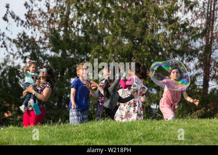 Kinder spielen mit riesigen seifenblasen am Seafair Sommer vierten Independence Day Feier am Gas Park am 4. Juli, 2019 in Seattle, Washington. Stockfoto