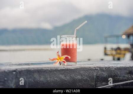 Ein Glas Guave Saft auf dem Hintergrund der See und die Berge. Gesunde Ernährung Konzept Stockfoto