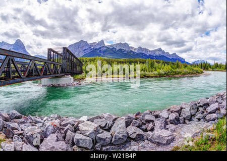 Historische Canmore Motor Brücke über den Bow River in der Kanadischen Rockies mit Ha Ling Peak und Mt Rundle im Hintergrund. Die Eisenbahnbrücke wurde b Stockfoto