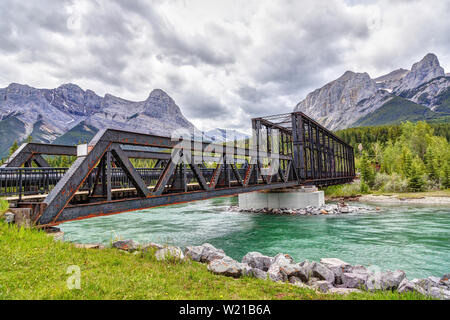 Historische Canmore Motor Brücke über den Bow River in der Kanadischen Rockies mit Ha Ling Peak und Mt Rundle im Hintergrund. Die Eisenbahnbrücke war bu Stockfoto