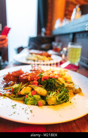 Geschmortes Kaninchen in dunkles Bier mit Kartoffelpüree und gedünstetes Gemüse. Nationale belgische Küche Stockfoto