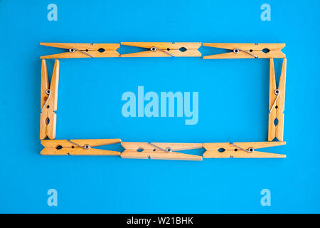 Runde oder rechteckige Rahmen aus Holz Wäscheklammern auf dem blauen Hintergrund. Ansicht von oben. Kopieren Sie Platz. Das Konzept der Natürlichkeit und Eco. Stockfoto