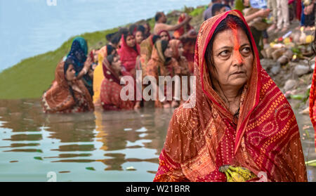 Frau mittleren Alters in Indischen Verschleiß mit Sindoor (Zinnober) auf Kopf, feiern Chhath Puja, die heiligen Bad im Fluss Ganges. Stockfoto