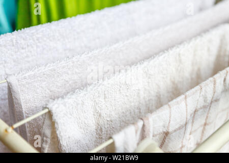 Weiße und farbige Bettwäsche und Handtücher auf der Wäscheleine getrocknet werden. Stockfoto