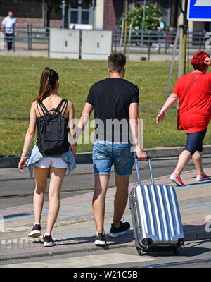 Junges Paar Spaziergänge auf der Straße mit Gepäck Stockfoto