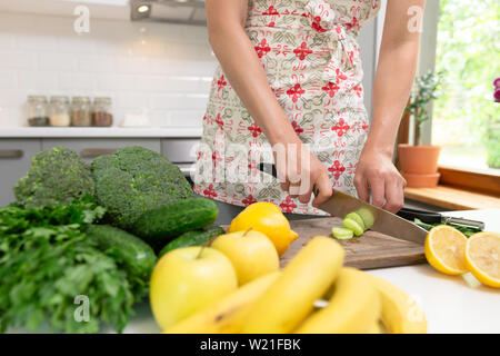 Frau hacken grünes Gemüse für detox Smoothie zu Hause. Gesunde Ernährung, Vegetarische Kost, Diäten Stockfoto