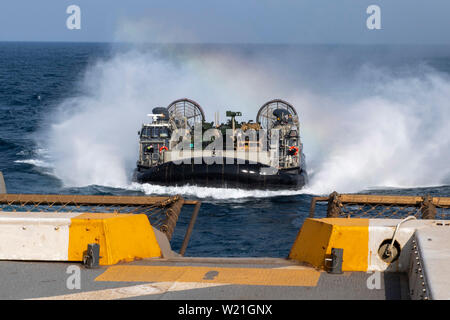 190703-N-NB 544-1187 Golf von Aden (3. Juli 2019) Landing Craft air cushion (LCAC) 58, zugeordnet zu den Angriff Craft Unit (ACU) 5, Ansätze der amphibious Transport dock Schiff USS John Murtha (LPD S. 26) während gut Deck. John Murtha ist derzeit auf ihrem ersten Einsatz und ein Teil der Boxer Amphibious Ready Gruppe und der 11 Marine Expeditionary Unit Team und ist für den 5. Bereich der Flotte zur Unterstützung der Marine im Einsatz für die Stabilität und Sicherheit in der Region zu gewährleisten und verbindet das Mittelmeer und den Pazifischen Raum durch den Westlichen Indischen Ozean und Th Stockfoto