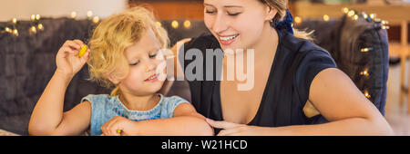 Ein Lehrer, ein Tutor für heimunterricht und ein Lehrer am Tisch. Oder Mutter und Tochter. Homeschooling BANNER, LANGE FORMAT Stockfoto