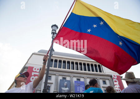 Eine Demonstrantin hält ein Flagge Venezuela während der Demonstration. Hunderte von venezolanischen Gegner im Exil in Madrid protest Hilfe aus Venezuela und für die Anwendung von Artikel 187.11 der venezolanischen Verfassung, in der die ausländische militärische Intervention in Venezuela erlauben würde, humanitäre Hilfe für die gegenwärtigen humanitären und wandernde Krise im Land zu bewerben und zu fordern, dass das Regime von Nicolas Maduro verweigert. Stockfoto