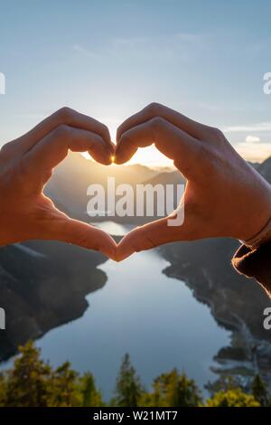 Hand bildet ein Herz vor der Alpen und Bergsee, Symbol der Liebe für die Natur und Wandern, Ansicht von Schonjochl, Plansee, Tirol, Österreich Stockfoto