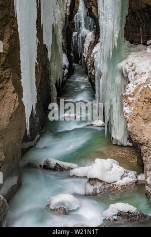 Pfad zur partnach wilden Fluss in die Partnachklamm mit langen eiszapfen und Schnee im Winter, in der Nähe von Garmisch-Partenkirchen, Oberbayern, Bayern, Deutschland Stockfoto