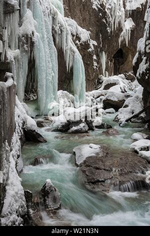 Wild River Partnach in der Partnachklamm mit langen eiszapfen und Schnee im Winter, in der Nähe von Garmisch-Partenkirchen, Oberbayern, Bayern, Deutschland Stockfoto