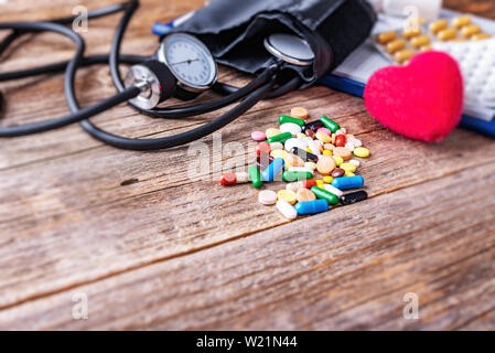 Tonometer Pillen und Herzen Modell auf einer hölzernen Hintergrund. Stockfoto